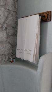 a towel hanging on a towel rack next to a bath tub at Milo Milo Suites in Mandrakia