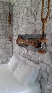 a bedroom with two beds and a stone wall at Milo Milo Suites in Mandrakia