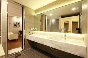 a bathroom with a tub, sink and mirror at Premium Ava Hotel in Busan