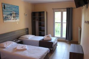 Les Voiles d'Azur في لا لوند-ليه-مور: غرفة فندقية بسريرين ونافذة