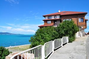 a house with a white fence next to the ocean at Villa Elea in Nesebar
