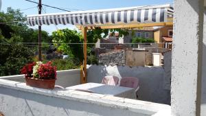a pink chair sitting on a balcony with an umbrella at Apartments Princip in Orlec