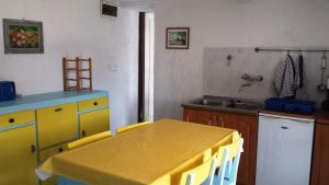 una cucina con tavolo giallo e lavandino di Apartments Princip a Orlec