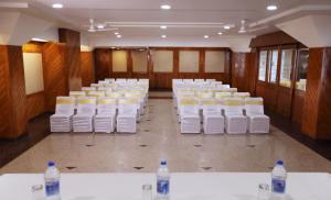 a room with rows of white chairs and water bottles at Hotel Vishnu Palace in Mussoorie