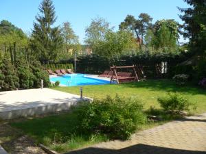 ein Garten mit Swimmingpool in einem Garten mit einem Garten in der Unterkunft Leśna Wisełka in Wisełka