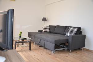 a living room with a couch and a tv at Surf & Sun Holiday Apartments in Limassol