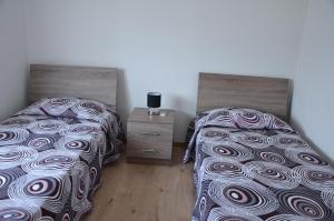 a bedroom with two beds and a night stand at Surf & Sun Holiday Apartments in Limassol