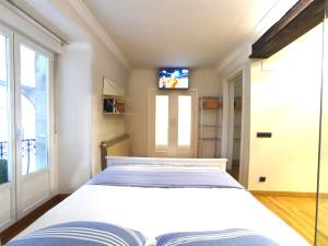 - une chambre avec un grand lit et une télévision dans l'établissement Luxury Arquillos Vitoria, à Vitoria-Gasteiz