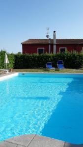 una gran piscina azul con 2 sillas azules en Casa Roffi Esposito, en Pieve di Santa Luce