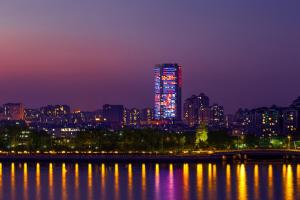 a tall building with red lights on it at night at Soluxe Hotel Guangzhou in Guangzhou