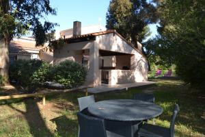 een tafel en stoelen voor een huis bij Les Voiles d'Azur in La Londe-les-Maures