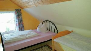 ein kleines Schlafzimmer mit einem Bett und einem Fenster in der Unterkunft Ferienhaus Riedl in Klingenthal