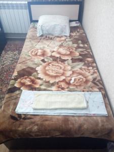 ピャチゴルスクにあるДом с уютными гостевыми комнатамиの花のテーブル付きベッド