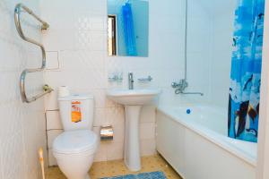 a bathroom with a toilet and a sink and a bath tub at Hotel Nurlytau in Borovoye +33 photos