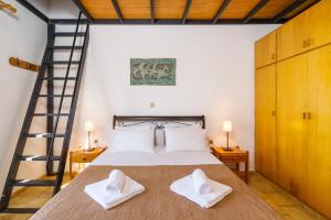 una camera con un letto e due asciugamani bianchi di Romanza Villas a Sitia