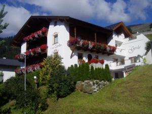 a white building with flowers on the side of it at Haus Gerda in Fiss