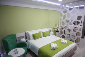a bedroom with a bed with a green accent wall at Lazuli Sea View-Beachfront Ap 405 in Larnaka