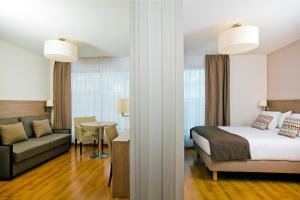 a hotel room with a bed and a couch at Residhome Bois Colombes Monceau in Bois-Colombes
