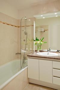 W łazience znajduje się wanna, umywalka i prysznic. w obiekcie Residhome Bois Colombes Monceau w mieście Bois-Colombes