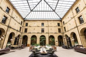 a large building with tables and chairs and a glass ceiling at Eurostars Los Agustinos in Haro