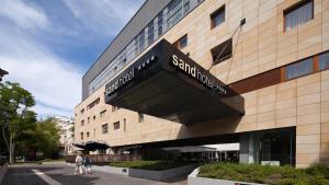 a building with a sign on the side of it at VacationClub - Sand Hotel Apartment 201 in Kołobrzeg