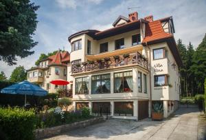 duży budynek z budynkiem z parasolem w obiekcie Villa Nina w Polanicy Zdroju