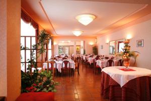 un comedor con mesas con manteles blancos en Hotel Villa Rosy en Premeno