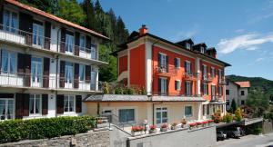 a group of buildings with flowers in front of them at Hotel Villa Rosy in Premeno