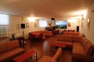 a waiting room with couches and chairs and a table at Hotel Villa Rosy in Premeno