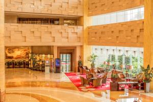 a lobby with chairs and tables in a building at Soluxe Hotel Guangzhou in Guangzhou +104 photos