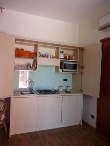 a kitchen with white cabinets and a microwave at Casabettina in Valderice
