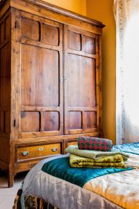 ローマにあるLa Casetta Di Tizianaのベッドルーム(大型の木製ドレッサー、ベッド1台付)