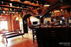 a bar with wooden tables and benches in a room at Ripple Hill Hotel in Patentie