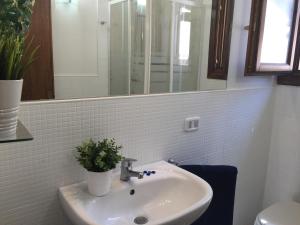 マカリにあるBlu Mareaのバスルーム(シンク、鏡、植物付)