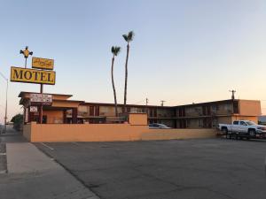un motel con un camión estacionado en un estacionamiento en Regalodge Motel, en Yuma