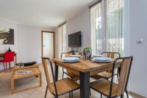 a dining room with a wooden table and chairs at Villa Velvet in Villeneuve-Loubet