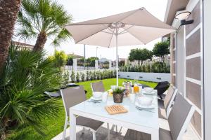 a white table with an umbrella on a patio at Villa Velvet in Villeneuve-Loubet