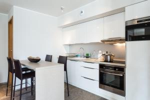 a kitchen with white cabinets and a table with chairs at Villa Velvet in Villeneuve-Loubet