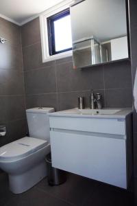 Lazuli Beach Apartment 209 في لارنكا: حمام مع مرحاض ومغسلة ومرآة