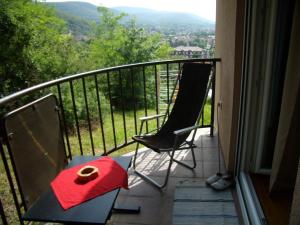 a balcony with two chairs and a red box on a table at Panorama 5 in Soko Banja
