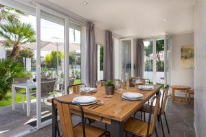 a dining room with a wooden table and chairs at Villa Velvet in Villeneuve-Loubet