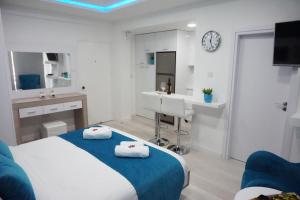 Lazuli Beach Apartment 209 في لارنكا: غرفة نوم بسرير ومغسلة وساعة