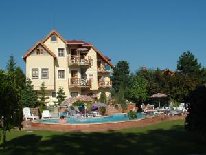 une grande maison avec une piscine en face de celle-ci dans l'établissement Castle house, à Balatonfüred