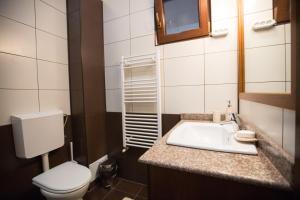 a bathroom with a white toilet and a sink at Bliss Residence - Aquamarine in Constanţa +6 photos