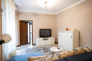 a living room with a couch and a tv at Bliss Residence - Aquamarine in Constanţa