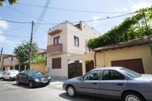 two cars parked on a street in front of a house at Bliss Residence - Aquamarine in Constanţa