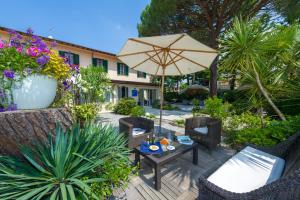 a patio with a table and an umbrella at Hotel La Pace in Forte dei Marmi