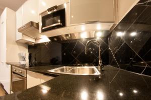 een keuken met een spoelbak en een magnetron bij Yourplace Biskupia Old Town Apartments in Krakau +174 foto's