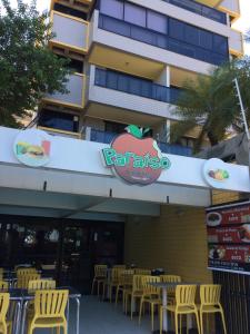 um restaurante com cadeiras amarelas em frente a um edifício em Beira Mar da Pajuçara em Maceió