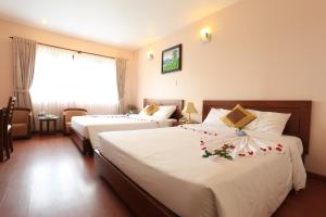 Postel nebo postele na pokoji v ubytování Ky Hoa Hotel Da Lat